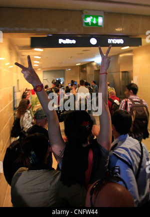 Un attivista di sinistra dà il segno della vittoria mentre viene arrestata all'aeroporto di ben-Gurion mentre gli attivisti pro-palestinesi arrivano come parte della 'Flytilla' il 15 aprile 2012. Centinaia di attivisti pro-palestinesi provenienti principalmente da paesi europei hanno acquistato biglietti aerei per Israele con l'obiettivo di recarsi in Cisgiordania palestinese nell'ambito della campagna "Benvenuti in Palestina”, che è stata denominata un Airflotilla2, o Flytilla, e si svolge per il terzo anno. Foto Stock