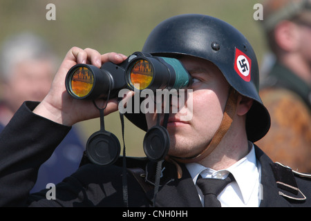 Soldato nazista che guarda attraverso il binocolo prodotte in Russia. Rievocazione della battaglia per Orechov (1945) in Orechov u Brna, Repubblica Ceca. La battaglia per Orechov in aprile 1945 durante la liberazione della Cecoslovacchia da parte delle truppe sovietiche, era uno degli ultimi grandi battaglie della Seconda Guerra Mondiale e l'ultima battaglia nel mondo Storia militare della cavalleria frequentato in cui. Foto Stock