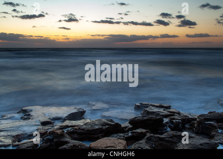 Un sunrise immagine presa a Washington oaks giardini del parco statale in Palm Coast, fl. Questo è sul lato oceano del parco. la roccia fuori-mozzare in questa immagine è composta da coquina rock, che è una combinazione di conchiglie di mare e sabbia legati insieme con calcite. Questa pietra è stata utilizzata per la costruzione nella zona per secoli. washington oaks gardens state park è situato a sud di st. Agostino nella città di palm coast. L'albergo era una volta di proprietà di un parente lontano di George Washington. I giardini, situato tra la costa e il fiume Mantanzas sono stati stabiliti da louise e owen Foto Stock