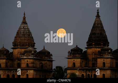 Luna piena insieme all'alba, dietro Cenotaphs, Orchha, Madhya Pradesh, India Foto Stock