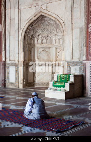 Agra, India. Taj Mahal moschea interni. L Imam la lettura del Corano mentre si attende il momento di preghiera. Foto Stock