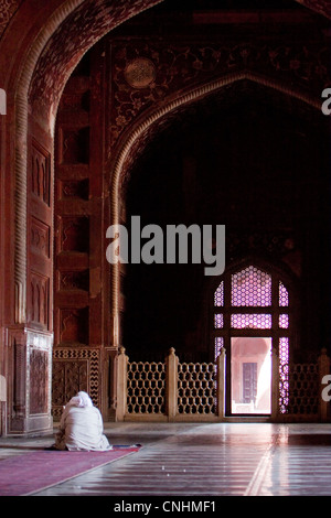 Agra, India. Taj Mahal interni. L Imam leggere il Corano in attesa il momento di preghiera. Foto Stock