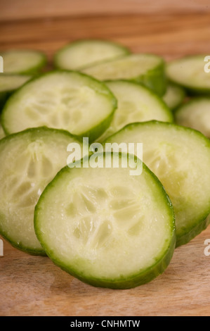 Fette di cetriolo continentale su un tagliere di legno Foto Stock