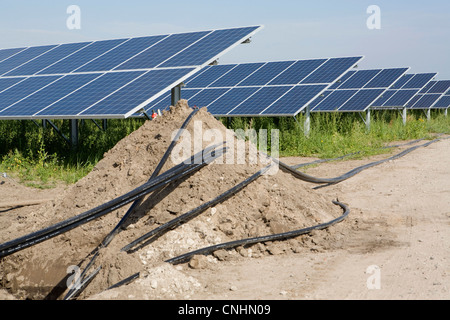 Dettaglio di tubi e pannelli solari installati in un campo Foto Stock