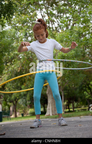 Ragazza con hula hoops in posizione di parcheggio Foto Stock