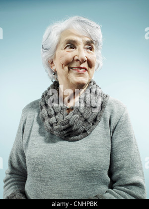 Un elegante senior donna sorridente e guardando lontano Foto Stock