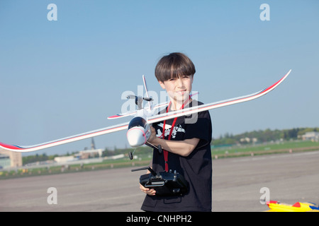 Ragazzo con il modello di aeroplano a l'aviosuperficie abbandonate all aeroporto di Tempelhof di Berlino Foto Stock