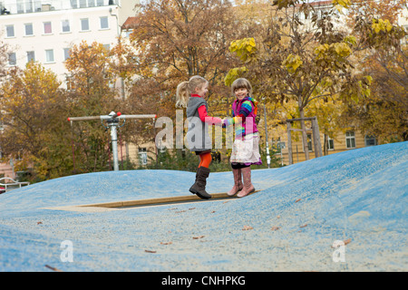Due ragazze rimbalzare sul trampolino di piccole dimensioni in posizione di parcheggio Foto Stock