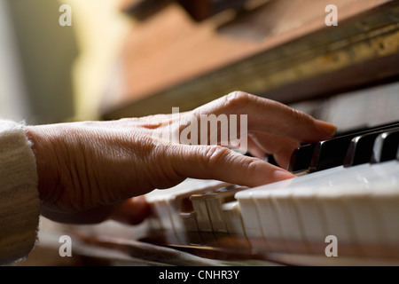 Pianoforte corda premuta dalla donna di mano Foto Stock