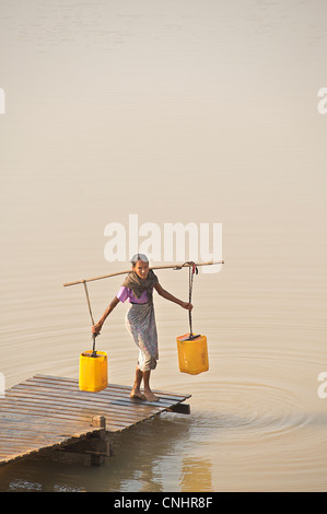 Donna birmano la raccolta dell'acqua da un serbatoio tra il Monte Popa e Bagan Birmania. Myanmar. Festival dell'acqua preparati Foto Stock