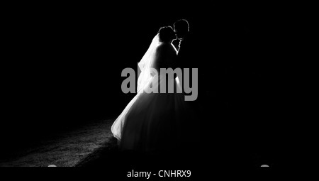 Silhouette della sposa e lo sposo baciare sul giorno di nozze Foto Stock