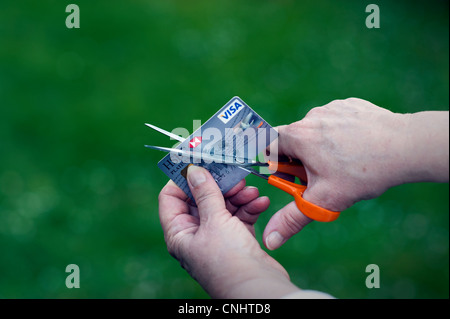 Tagliare le carte di credito per ridurre il debito. I nomi e i dettagli del conto prelevato in Photo-Shop per la sicurezza. Foto Stock