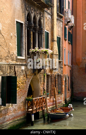 Canale veneziano con piccola imbarcazione per la porta anteriore, Venezia Foto Stock