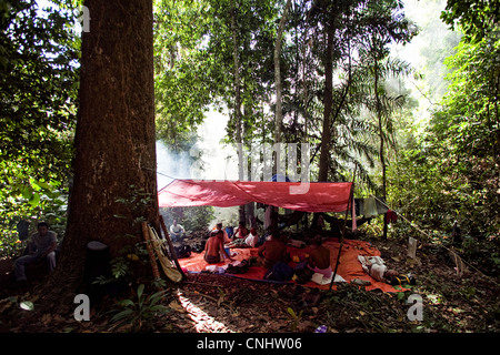 I cacciatori di riposo durante il giorno nel campo nella giungla vicino Gubir in Malesia Foto Stock