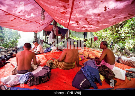 I cacciatori di riposo durante il giorno nel campo nella giungla vicino Gubir in Malesia Foto Stock