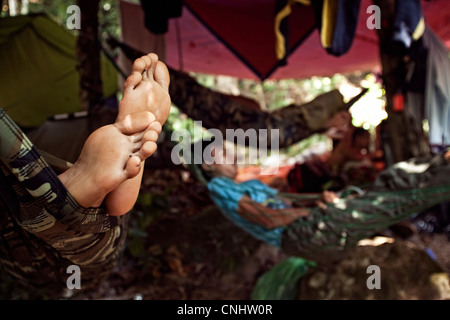 I cacciatori di riposo durante il giorno nel campo nella giungla vicino Gubir in Malesia Foto Stock