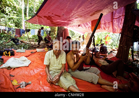 I cacciatori di riposo durante il giorno nel campo nella giungla vicino Gubir in Malesia Foto Stock