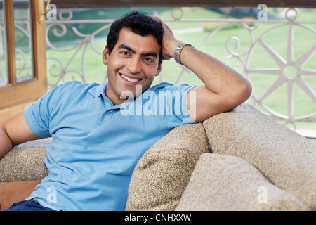 Ritratto di un uomo seduto su un divano Foto Stock