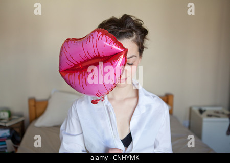 Giovane donna con labbra palloncino a forma di Foto Stock