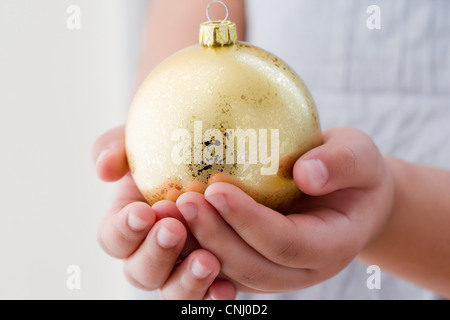 Ragazza con un oro Pallina natale Foto Stock