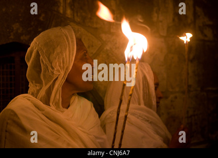 Ortodossa Etiope di adoratori di tenere candele durante il fuoco santo cerimonia presso il Santo Sepolcro di Gerusalemme Foto Stock