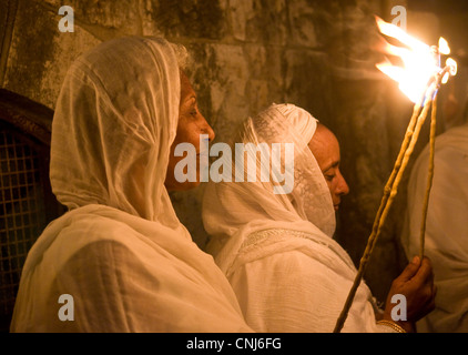 Ortodossa Etiope di adoratori di tenere candele durante il fuoco santo cerimonia presso il Santo Sepolcro di Gerusalemme Foto Stock