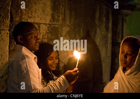 Ortodossa Etiope di adoratori di tenere candele durante il fuoco santo cerimonia presso il Santo Sepolcro di Gerusalemme Foto Stock