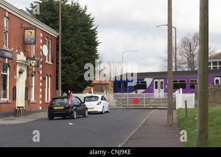 Il traffico in attesa per il treno passare all'azionato manualmente il passaggio a livello ferroviario a Daisyfield, Moss Street, Blackburn. Foto Stock