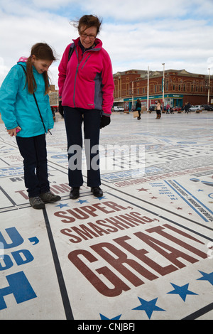Madre e figlia sul lungomare di Blackpool guardando il tappeto di commedia, Lancashire, Inghilterra Foto Stock