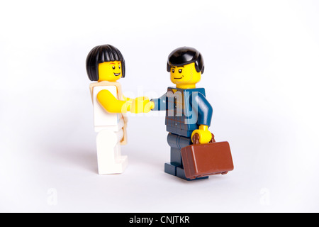 Due toy Lego la gente di affari agitando mani in alto sullo sfondo della chiave Foto Stock