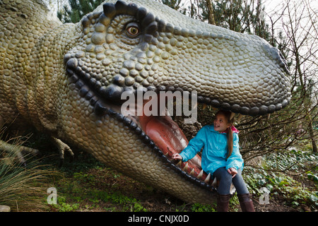 Ragazza seduta nella bocca del Tyrannosaurus rex nel dinosauro Safari a Blackpool Zoo Foto Stock