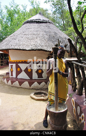 Ragazza la macinazione del grano in pazienti pediatrici village, Lesedi African Villaggio Culturale, Broederstroom, Johannesburg Gauteng, Sud Africa Foto Stock