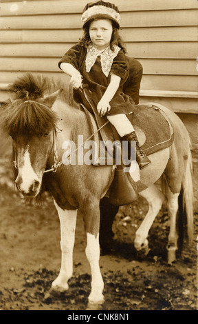 Carino Bambina a cavallo di un pony Foto Stock