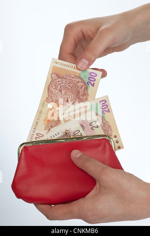 Donna di mano la rimozione di un South African Rand 200 nota dal suo portamonete rosso Foto Stock