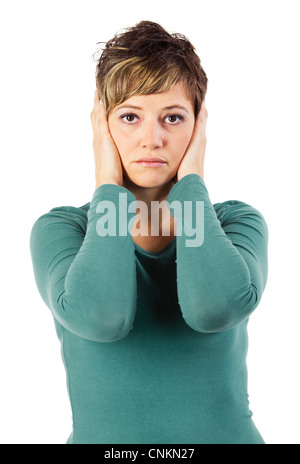 Triste guardando giovane donna che copre le sue orecchie come una delle tre scimmie. Isolato studio shot contro uno sfondo bianco. Foto Stock