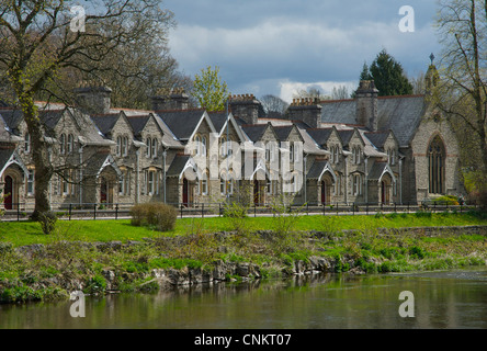 Sleddall gli ospizi di carità, sulla strada Aynam, Kendal e fiume Kent, Cumbria, Regno Unito Inghilterra, con Kendal Castle in background Foto Stock