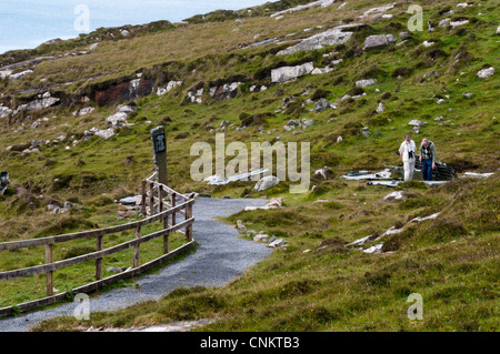 I turisti in un memoriale sulla Vatersay per le vittime e i sopravvissuti di un Catalina Flying Boat crash durante la seconda guerra mondiale nel 1944. Foto Stock