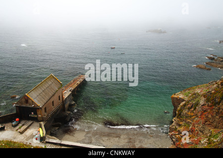 Il vecchio R.N.L.I. in disuso Lizard scialuppa di salvataggio stazione presso Polpeor Cove, Lizard Point, Cornwall, Regno Unito. Foto Stock