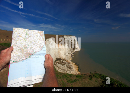 Maschio adulto in piedi con OS mappa presso le Bianche Scogliere di Dover contea del Kent England Regno Unito Regno Unito Foto Stock