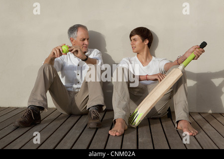 Padre e Figlio con il cricket bat sul patio Foto Stock