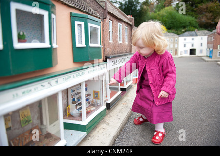 Una bambina si aggira intorno le strade di Wimborne Model Village a Wimborne, Dorset Foto Stock