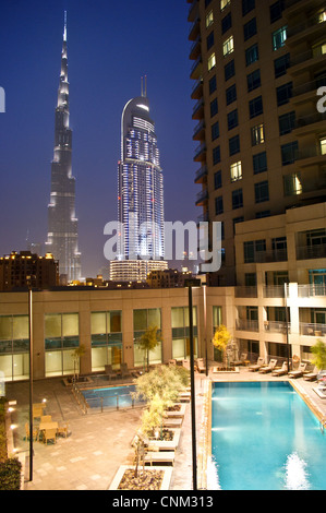 Il Burj Khalifa, Dubai e il centro cittadino di indirizzo tower, al tramonto, visto dalla piscina di Burj viste, Emirati Arabi Uniti Foto Stock