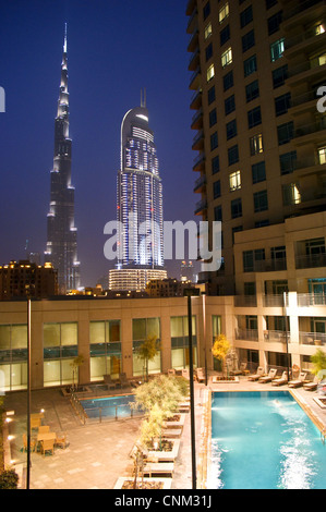 Il Burj Khalifa, Dubai e il centro cittadino di indirizzo tower, al tramonto, visto dalla piscina di Burj viste, Emirati Arabi Uniti Foto Stock