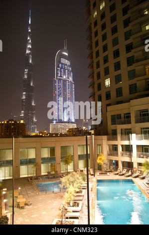 Il Burj Khalifa, Dubai e il centro cittadino di indirizzo tower, al tramonto, visto dalla piscina di Burj viste, Emirati Arabi Uniti Foto Stock