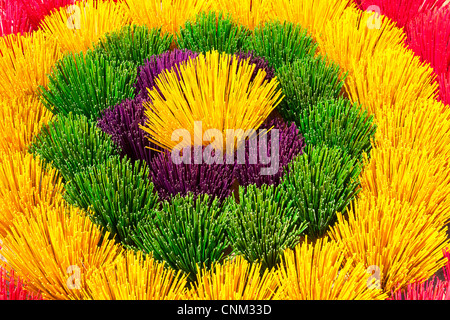 Fasci colorati di bastoncini di incenso in vendita, disposti come un fiore, Xuan Thuy Hat Village, vicino a tonalità, Vietnam Foto Stock