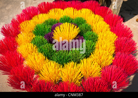 Fasci colorati di bastoncini di incenso in vendita, disposti come un fiore, Xuan Thuy Hat Village, vicino a tonalità, Vietnam Foto Stock