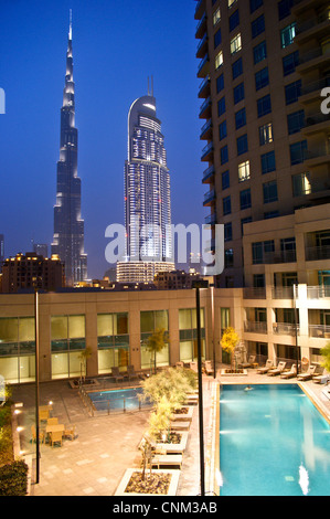 Il Burj Khalifa, Dubai e il centro cittadino di indirizzo tower, al tramonto, visto dalla piscina di Burj viste, Emirati Arabi Uniti Foto Stock