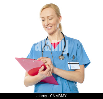 Ritratto di felice senior medico iscritto negli appunti isolate su sfondo bianco Foto Stock