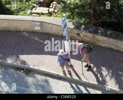 Coppia in pensione in attesa del bus per Qawra, Malta, Europa Foto Stock