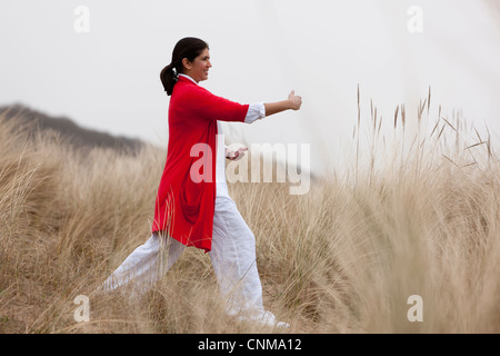 La donna a praticare yoga sulla spiaggia Foto Stock